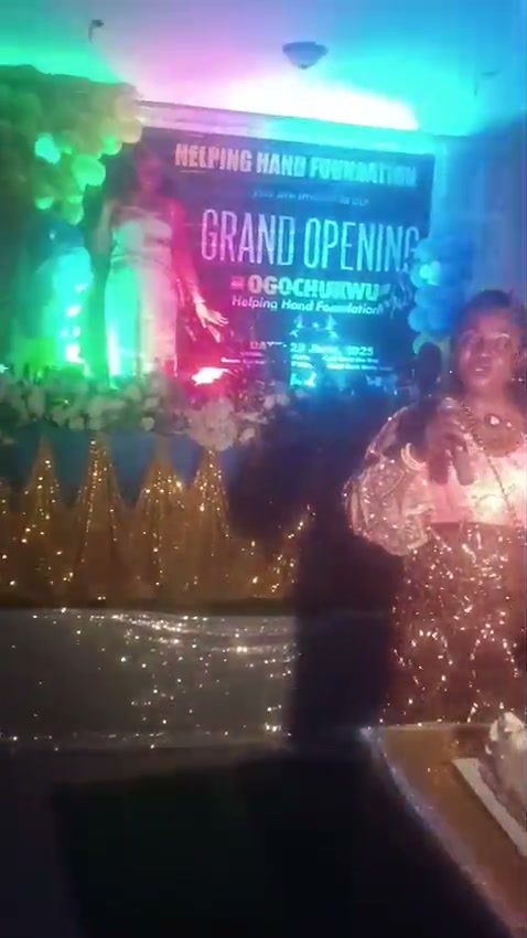 Nurse Vivian Okafor standing with children beside the cake at the grand opening of Ogochukwu Helping Hands Foundation