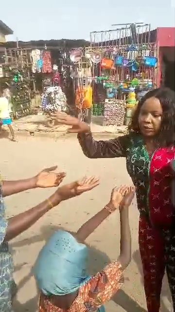 Nurse Vivian Okafor distributing food by hand in a busy market street, surrounded by people reaching out to receive it