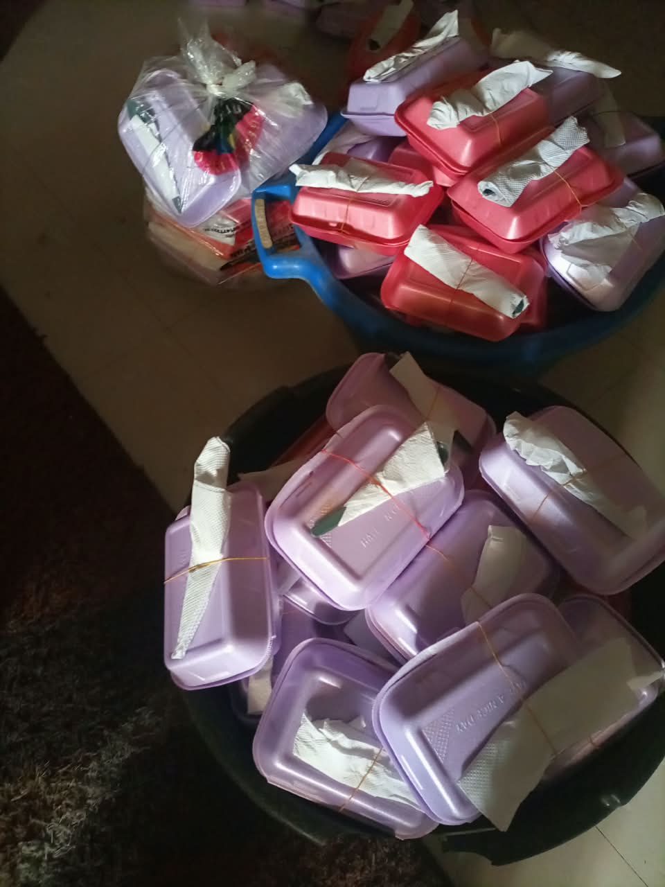 Basins of packed meals prepared by the team for a community outreach