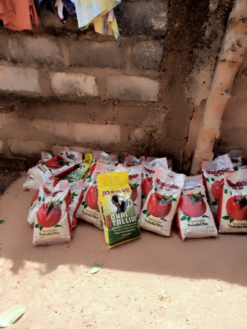 Bags of parboiled rice lined up on the ground ready to be shared out